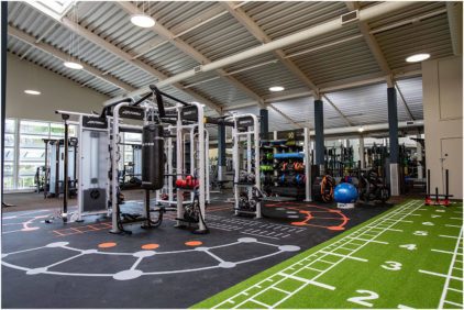 A spacious, well-equipped gym with workout stations and exercise equipment.