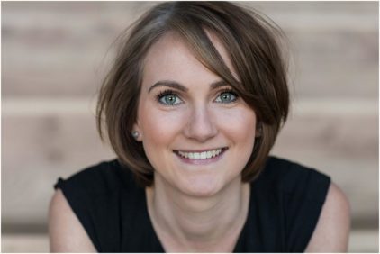 A woman with short brown hair smiling.
