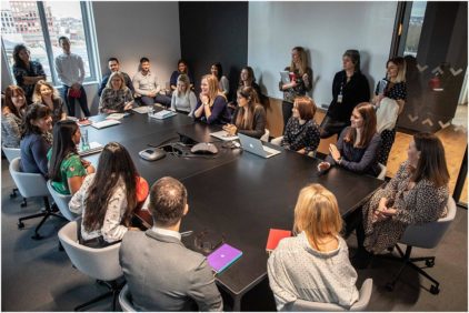A group of people engaged in a meeting around a large conference table.