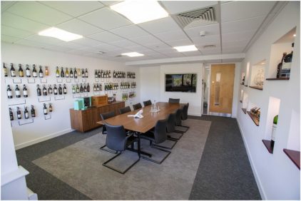 A conference room with a table, chairs, and walls lined with wine bottles.