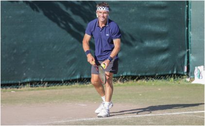 Outdoor image of a tennis player in action on a grass court.