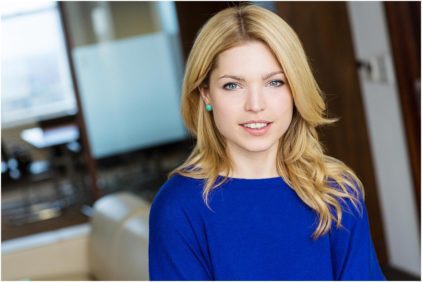 Portrait of a woman indoors wearing a blue top.