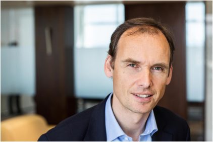 Portrait of a man indoors with a professional background.