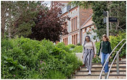 Outdoor image of two people walking down steps surrounded by greenery.