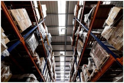 Indoors image of tall warehouse shelves filled with wrapped packages.
