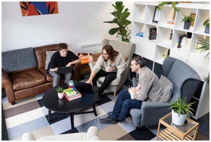 Three people collaborating in a cozy indoor office setting.