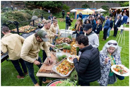 Outdoor event with people enjoying a buffet-style meal.