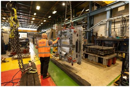 Industrial image of a factory worker operating machinery indoors.