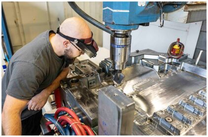 An indoor image of a man using a large industrial machine.