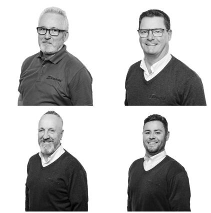 Black and white portraits of four men wearing glasses and sweaters.